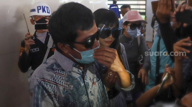Komedian Kiwil bersama dengan istri mudanya, Eva Bellissima ketika ditemui awak media saat tiba di Terminal 2 Bandara Soekarno Hatta, Tangerang, Banten, Rabu (16/12). [Suara.com/Alfian Winanto]