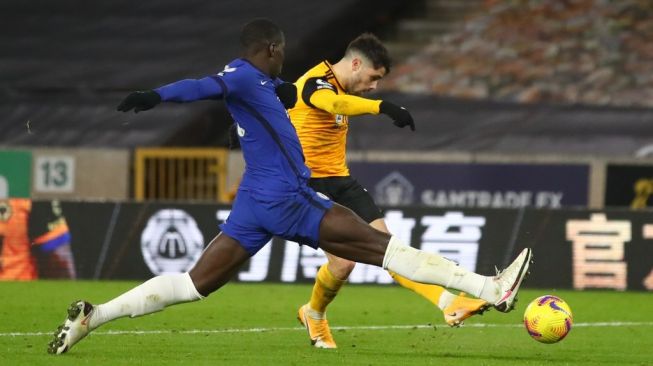 Penyerang Wolves Pedro Neto (kanan) melepaskan tembakan untuk mencetak gol penentu kemenangan atas Chelsea dalam lanjutan Liga Inggris di Stadion Molineux, Wolverhampton, Inggris, Rabu (16/12/2020) dini hari WIB. [Michael Steele / POOL / AFP]