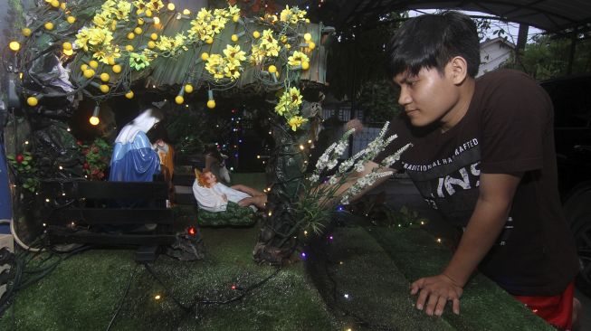 Seorang pemuda menata patung diorama kelahiran Yesus Kristus di teras rumahnya di Pontianak, Kalimantan Barat, Rabu (16/12/2020). [ANTARA FOTO/Jessica Helena Wuysang]