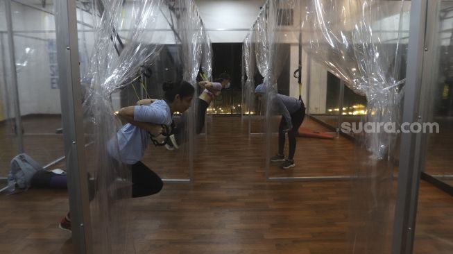 Warga mengikuti program latihan kebugaran TRX (total body resistance exercise) di Kaloria Studio, Jalan Ampera Raya, Jakarta, Rabu (16/12/2020). [Suara.com/Angga Budhiyanto]