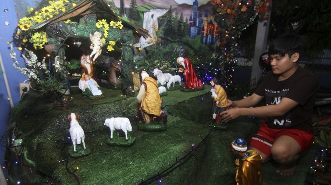 Seorang pemuda menata patung diorama kelahiran Yesus Kristus di teras rumahnya di Pontianak, Kalimantan Barat, Rabu (16/12/2020). [ANTARA FOTO/Jessica Helena Wuysang]