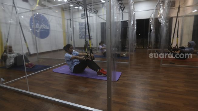 Warga mengikuti program latihan kebugaran TRX (total body resistance exercise) di Kaloria Studio, Jalan Ampera Raya, Jakarta, Rabu (16/12/2020). [Suara.com/Angga Budhiyanto]