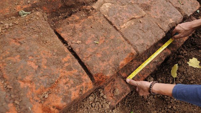 Anggota Klaten Heritage Community mengukur temuan struktur batu bata kuno yang tertata di lahan persawahan, di Gempol, Karanganom, Klaten, Jawa Tengah, Kamis (17/12/2020). ANTARA FOTO/Aloysius Jarot Nugroho