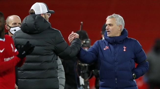 Pelatih Tottenham Hotspur Jose Mourinho (kanan) dan pelatih Liverpool Jurgen Klopp bersalaman usai pertandingan pekan ke-13 Liga Inggris di Stadion Anfield, Kamis (17/12/2020) dini hari WIB. [Clive Brunskill / POOL / AFP]