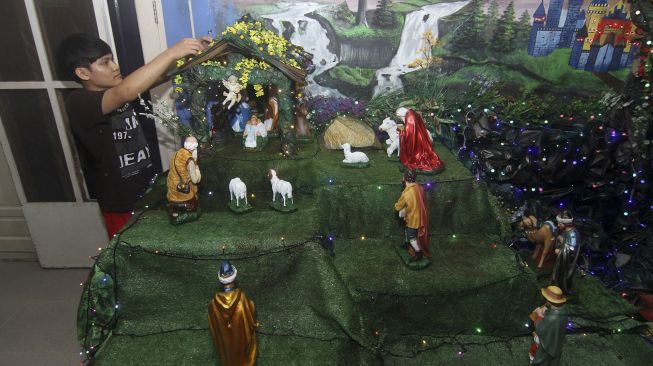 Seorang pemuda menata lampu hias diorama kelahiran Yesus Kristus di Pontianak, Kalimantan Barat, Rabu (16/12/2020). [ANTARA FOTO/Jessica Helena Wuysang]