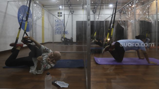 Warga mengikuti program latihan kebugaran TRX (total body resistance exercise) di Kaloria Studio, Jalan Ampera Raya, Jakarta, Rabu (17/12/2020). [Suara.com/Angga Budhiyanto]