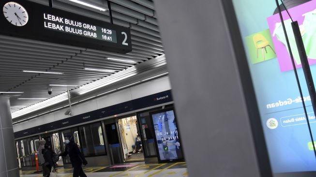 Penumpang menaiki kereta MRT di Stasiun MRT Bundaran HI, Jakarta, Jumat (18/12/2020). [ANTARA FOTO/Indrianto Eko Suwarso]