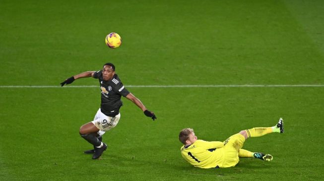 Penyerang Manchester United Anthony Martial (kiri) menaklukan kiper Aaron Ramsdale sebelum merobek gawang Sheffiled United dalam laga pekan ke-13 Liga Inggris di stadion Bramall Lane, Jumat (18/12/2020) dini hari WIB. [Laurence Griffiths / POOL / AFP]