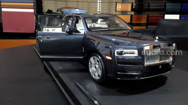 Model Rolls-Royce Cullinan dengan latar belakang kiri pilihan warna kulit upholstery dan door-trim serta kanan adalah pilihan wooden panel [Suara.com/CNR ukirsari].