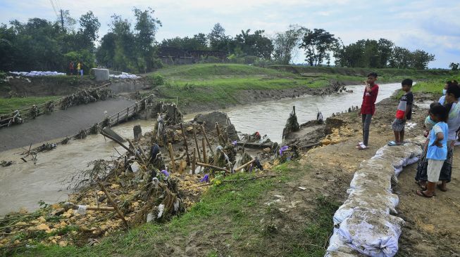 Warga melihat jembatan roboh di Desa Anggaswangi, Godong, Grobogan, Jawa Tengah, Jumat (18/12/2020). [ANTARA FOTO/Yusuf Nugroho]