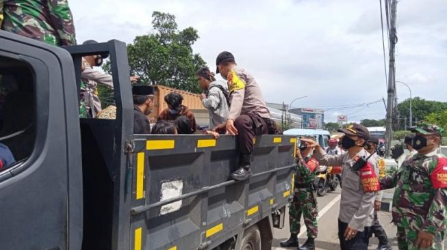 Petugas gabungan menjaring massa yang hendak ikut Aksi 1812 dalam operasi kemanusiaan di Tangerang, Jumat (18/12/2020). [Ist]