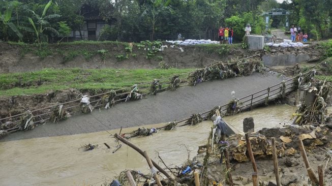 Warga melihat jembatan roboh di Desa Anggaswangi, Godong, Grobogan, Jawa Tengah, Jumat (18/12/2020). [ANTARA FOTO/Yusuf Nugroho]