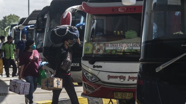 Calon penumpang berjalan menuju bus di Terminal Terpadu Pulo Gebang, Jakarta, Sabtu (19/12/2020). [ANTARA FOTO/Aprillio Akbar]