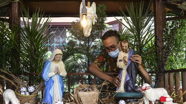 Petugas memasang dekorasi Natal di Gereja Santa Theresia, Menteng, Jakarta, Minggu (20/12/2020).  [ANTARA FOTO/M Risyal Hidayat]