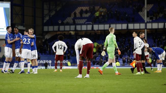 Para pemain Everton merayakan kemenangan selama pertandingan sepak bola Liga Premier Inggris antara Everton melawan Arsenal di Stadion Goodison Park, Liverpool, Inggris, Minggu (20/12/2020) dini hari WIB. Clive Brunskill / POOL / AFP