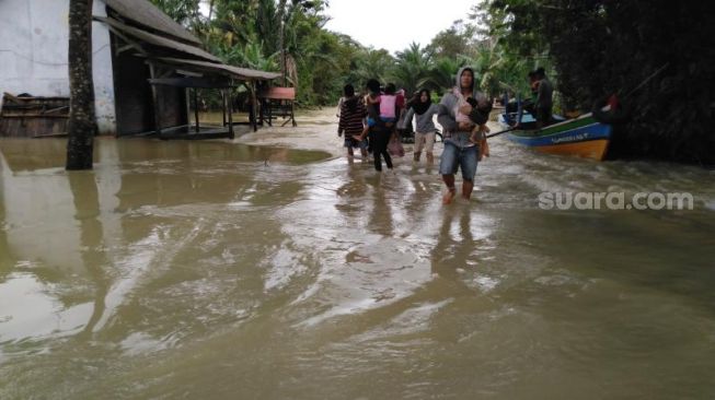 Kondisi banjir di Desa Pagelaran yang membuat akses jalan ke Kecamatan Patia, Kabupaten Padeglang, terputus pada, Senin (21/12/2020). [Suara.com/Saepulloh]