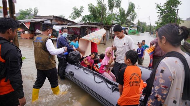 Wakil Gubernur Sulsel Andi Sudirman Sulaiman bersama petugas mengevakuasi korban banjir, Minggu (20/12/2020) / [Foto: Istimewa]