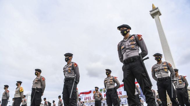 Anggota kepolisian mengikuti Apel Gelar Pasukan Operasi Lilin Jaya 2020 di kawasan Monumen Nasional (Monas), Jakarta, Senin (21/12/2020).  [ANTARA FOTO/Hafidz Mubarak]
