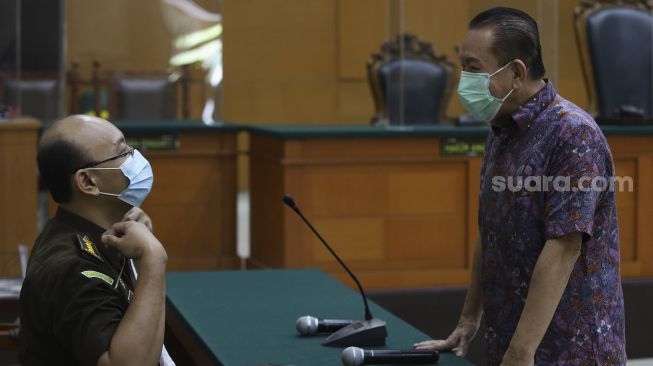 Terpidana kasus cessie Bank Bali Djoko Soegiarto Tjandra (kanan) selaku terdakwa perkara suap kepada jaksa dan perwira tinggi Polri serta pemufakatan jahat, berbincang dengan jaksa penuntut umum sebelum menjalani sidang pembacaan vonis di Pengadilan Negeri Jakarta Timur, Selasa (22/12/2020). [Suara.com/Angga Budhiyanto]