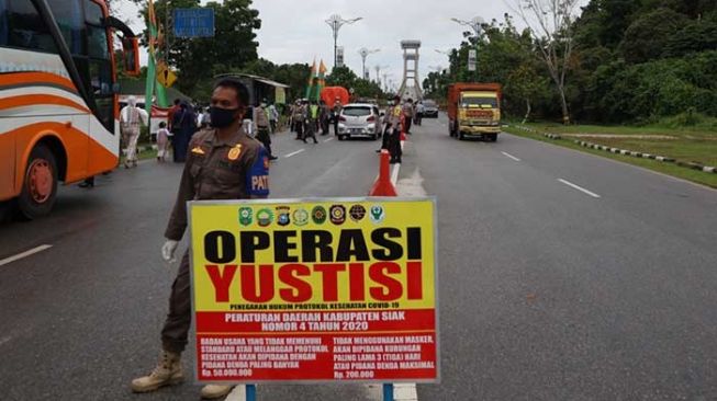 Operasi Tim Yustisi pelanggaran protokol kesehatan di Siak, Riau, Senin (21/12/2020). [Suara.com/Alfat Handri]