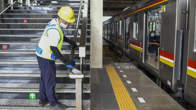 Petugas membersihkan area Stasiun Jatinegara Baru, Jakarta, Selasa (22/12/2020). [ANTARA FOTO/Galih Pradipta]