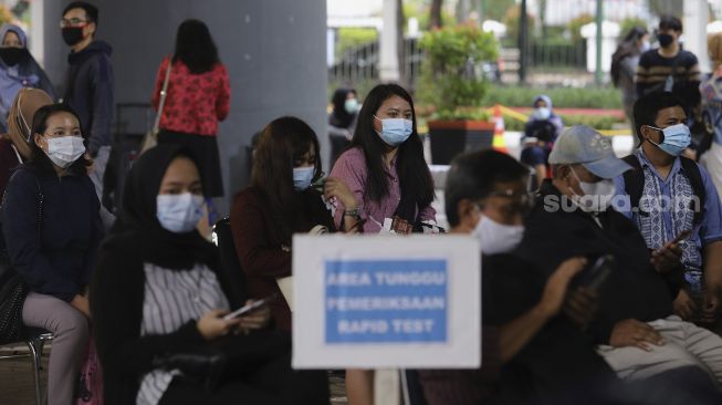 Sejumlah calon penumpang mengantre untuk mengikuti rapid tes antigen di Stasiun Gambir, Jakarta, Selasa (22/12/2020). [Suara.com/Angga Budhiyanto]