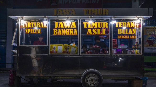 Pedagang makanan melayani pembeli di salah satu ruas jalan di Kota Poso, Kabupaten Poso, Sulawesi Tengah, Selasa (22/12/2020) malam.  [ANTARA FOTO/Basri Marzuki]
