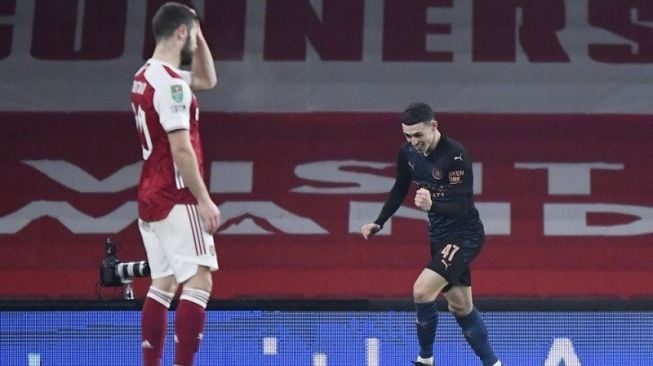  Gelandang serang Manchester City Phil Foden (kanan) merayakan golnya sementara bek Arsenal Shkodran Mustafi tampak kecewa dalam laga perempat final Piala Liga Inggris di Stadion Emirates, London, Inggris, Selasa (22/12/2020) waktu setempat. (ANTARA/REUTERS/Toby Melville)