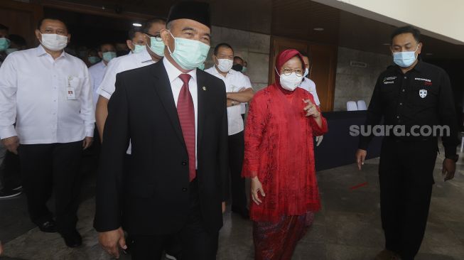 Menteri Koordinator Bidang Pembangunan Manusia dan Kebudayaan yang juga pejabat lama Menteri Sosial Ad Interim Muhajir Effendi (kedua kiri) bersama Menteri Sosial Tri Rismaharini (kedua kanan) bergegas usai menghadiri acara serah terima jabatan Menteri Sosial di Kantor Kementerian Sosial, Jakarta, Rabu (23/12/2020). [Suara.com/Angga Budhiyanto]