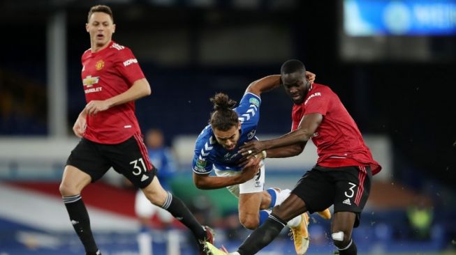 Bek Manchester United Eric Bailly (kanan) melakukan tekel terhadap penyerang Everton Dominic Calvert-Lewin dalam laga perempat final Piala Liga Inggris di Godison Park, Kamis (24/12/2020) dini hari WIB. [Nick Potts / POOL / AFP]