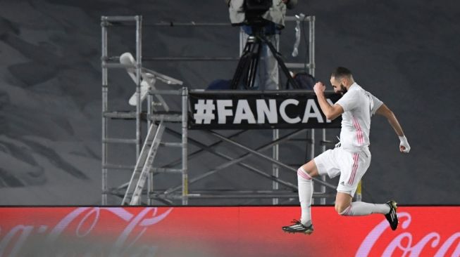 Penyerang Real Madrid, Karim Benzema (kiri) merayakan gol saat menghadapi Granada dalam laga pekan ke-15 Liga Spanyol, di Stadion Alfredo Di Stefano, Madrid, Kamis (24/12/2020) dini hari WIB. [OSCAR DEL POZO / AFP]