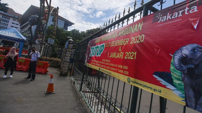 Petugas keamanan menjelaskan kepada warga terkait penutupan Taman Margasatwa Ragunan di Jakarta Selatan, Jumat (25/12/2020). [ANTARA FOTO/Sigid Kurniawan]
