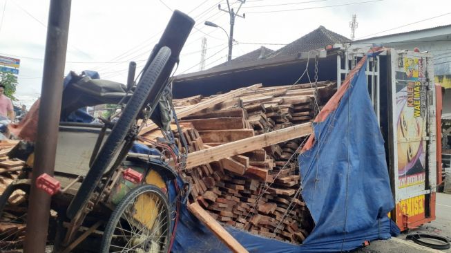 Truk Terguling, Becak dan Sepeda Motor Tertimpa Muatan Kayu