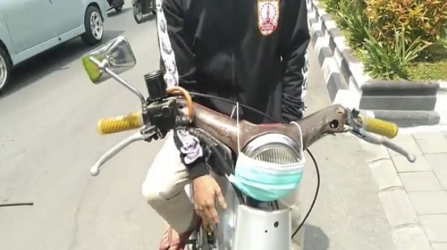 Pemuda yang memasang masker di lampu seppeda motor dan terjaring razia di Solo. (Instagram/@polrestasurakarta)