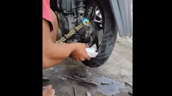 Soerang pria tengah mengisi ban motor dengan menggunakan tepung tapioka (Facebook)