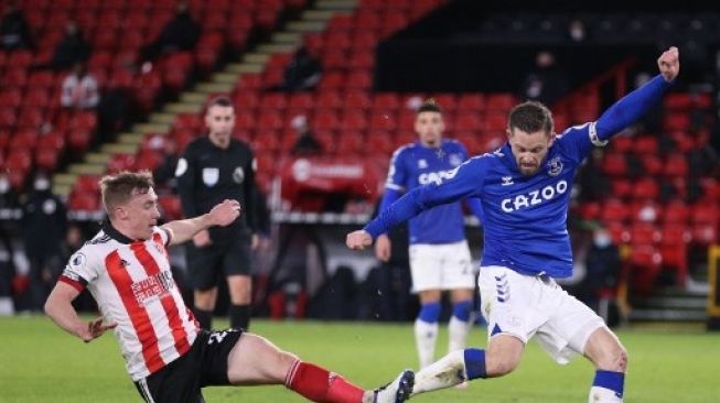 Pemain Everton, Gylfi Sigurdsson saat mencetak gol ke gawang Sheffield United di Bramall Lane, 26 Desember 2020. (ALEX PANTLING / POOL / AFP)