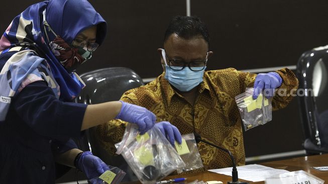 Komisioner Komnas HAM Choirul Anam (kanan) bersiap menunjukkan barang bukti hasil penyelidikan saat konferensi pers di Gedung Komisi Nasional Hak Asasi Manusia, Jakarta, Senin (28/12/2020). [Suara.com/Angga Budhiyanto]