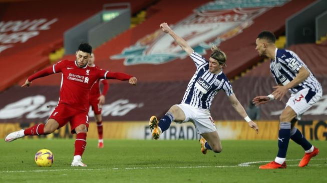 Gelandang Liverpool Alex Oxlade-Chamberlain melakukan tembakan namun gagal berbuah gol saat menghadapi West Brom dalam laga pekan ke-15 Liga Inggris di Stadion Anfield, Senin (28/12/2020) dini hari WIB. [Clive Brunskill / POOL / AFP]