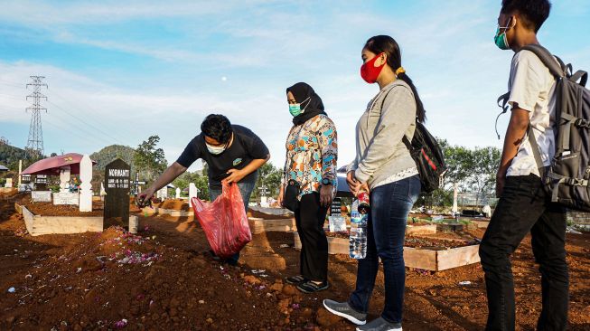 Sejumlah keluarga korban berziarah di tempat pemakaman khusus COVID-19 di Buper Waena, Kota Jayapura, Papua, Senin (28/12/2020).  ANTARA FOTO/Indrayadi TH