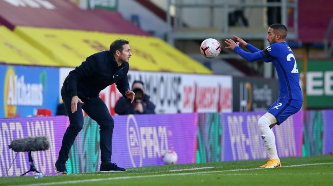 Manajer Chelsea Frank Lampard melempar bola dari pinggir lapangan kepada winger anyar The Blues, Hakim Ziyech saat menghadapi Burnley dalam laga lanjutan Liga Inggris di stadion Turf Moor, 31 Oktober 2020. [Alex Livesey / POOL / AFP].