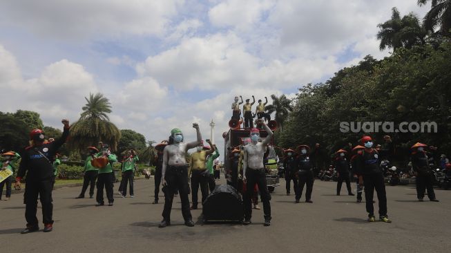 Sejumlah massa buruh yang tergabung dalam Konfederasi Serikat Pekerja Indonesia (KSPI) melakukan aksi unjuk rasa di kawasan Patung Kuda Arjuna Wiwaha, Jakarta, Selasa (29/12/2020). [Suara.com/Angga Budhiyanto]