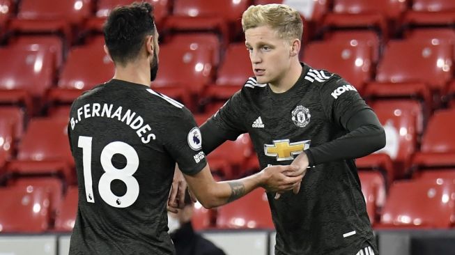 Gelandang serang Manchester United, Donny van de Beek (kanan) masuk lapangan menggantikan gelandang serang Bruno Fernandes di laga Liga Inggris 2020/2021, 17 Desember lalu. [PETER POWELL / POOL / AFP]