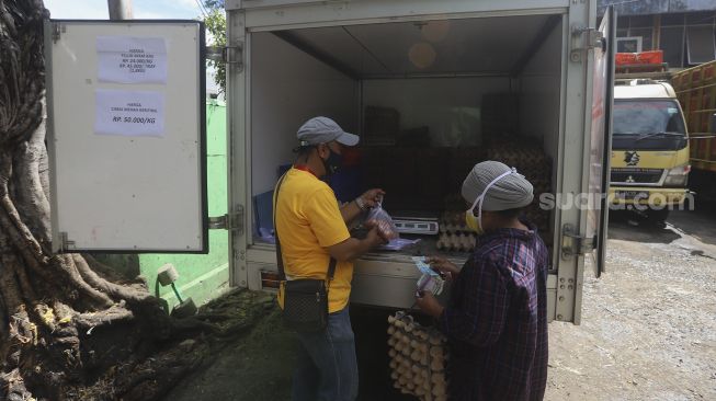 Petugas melayani pembeli telur saat Gelar Pangan Murah (GPM) di Pasar Cipete Utara, Jakarta, Selasa (29/12/2020). [Suara.com/Angga Budhiyanto]