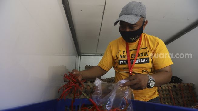 Petugas melayani pembeli cabai saat Gelar Pangan Murah (GPM) di Pasar Cipete Utara, Jakarta, Selasa (29/12/2020). [Suara.com/Angga Budhiyanto]