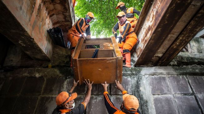 Sejumlah petugas PPSU mengangkut lemari saat menertibkan hunian liar di kolong jembatan Jalan Proklamasi, Pegangsaan, Menteng, Jakarta, Selasa (29/12/2020). [ANTARA FOTO/Aprillio Akbar]
