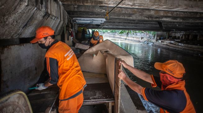 Petugas PPSU menertibkan hunian liar di kolong jembatan Jalan Proklamasi, Pegangsaan, Menteng, Jakarta, Selasa (29/12/2020). [ANTARA FOTO/Aprillio Akbar]

