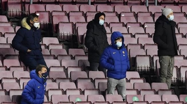 Kapten Barcelona Lionel Messi (tengah) menyaksikan pertandingan timnya kontra Eibar di ajang La Liga dari tribun stadion Camp Nou, Rabu (30/12/2020). [AFP]