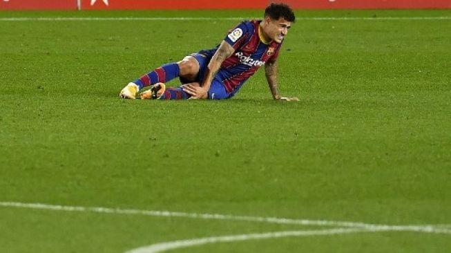 Pemain Barcelona Philippe Coutinho mengerang kesakitan saat menghadapi Eibar di Camp Nou dalam lanjutan La Liga pada 30 Desember 2020. [AFP]