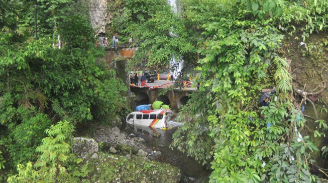 Sebuah minibus tercebur sungai usai mengalami Tabrakan beruntun di Kawasan Lembah Anai, Kabupaten Tanah Datar, Sumatera Barat, Rabu (30/12/2020). ANTARA FOTO/Iggoy el Fitra
