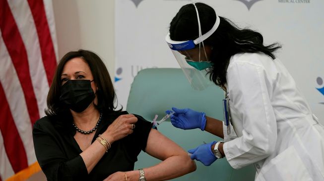 Perawat Patricia Cummings menyuntikan vaksin COVID-19 kepada Wakil Presiden terpilih Kamala Harris di United Medical Center di Washington, DC, Amerika Serikat, Selasa (29/12).  [Alex Edelman / AFP]